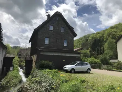 Mühlhaus am Bach mit freundlichem Hund